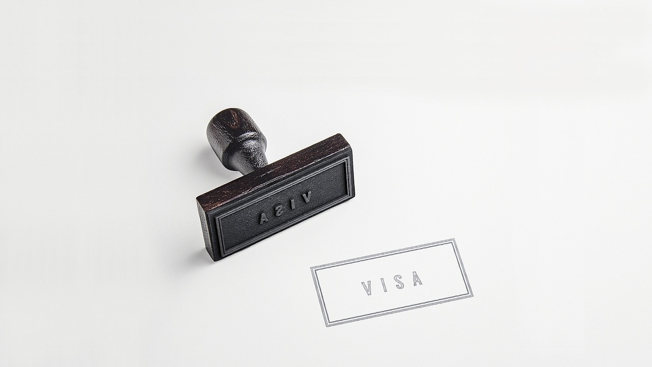 Saudi visa application form on a laptop screen with passport next to it