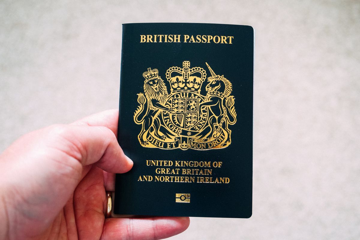 UK passport next to a laptop displaying the Saudi e-visa application website