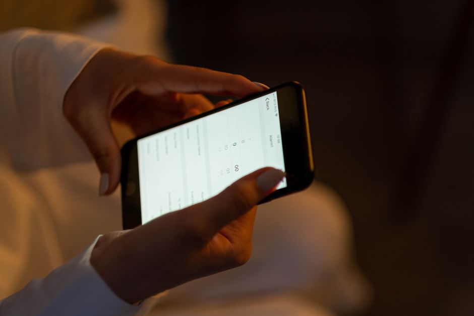 Person using smartphone for travel booking, representing Nusuk app usage