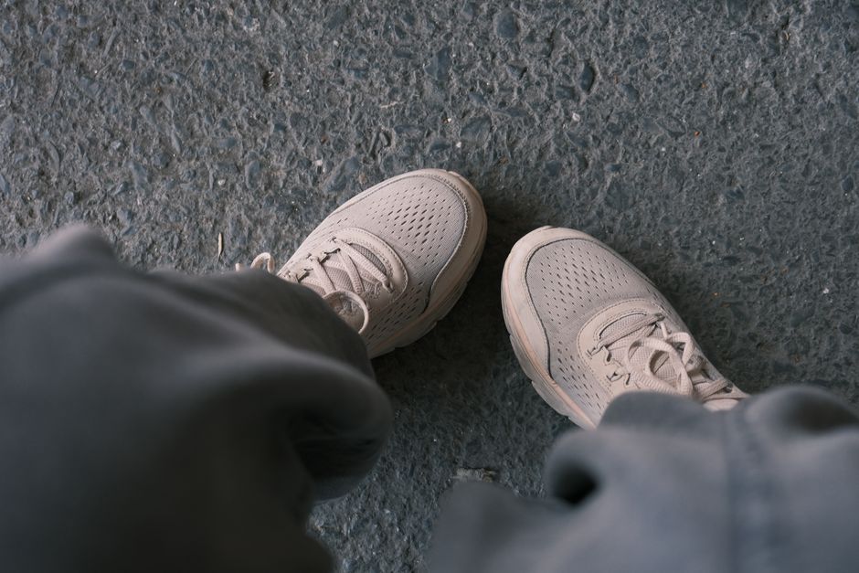 Casual white sneakers on textured pavement, ideal for travel comfort