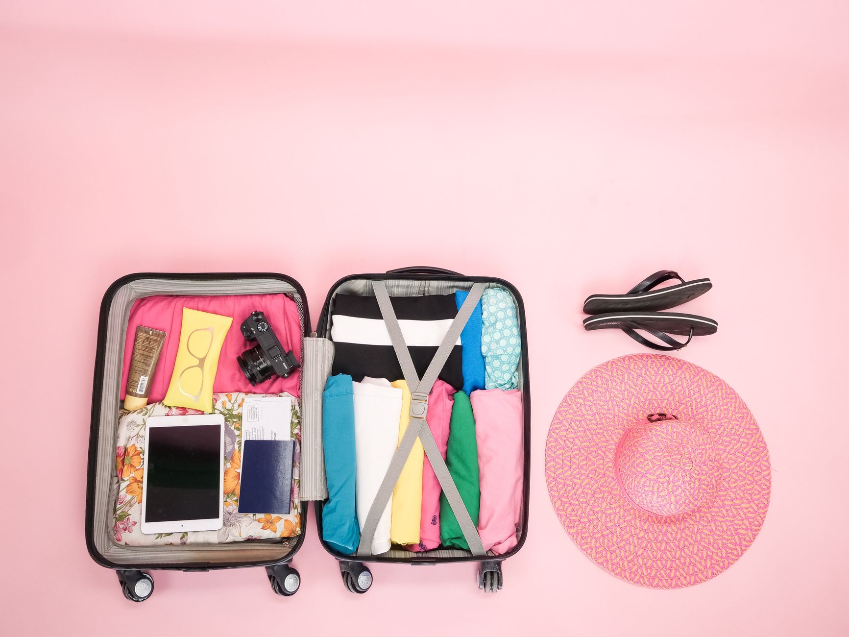 Open suitcase packed neatly with clothing and travel essentials