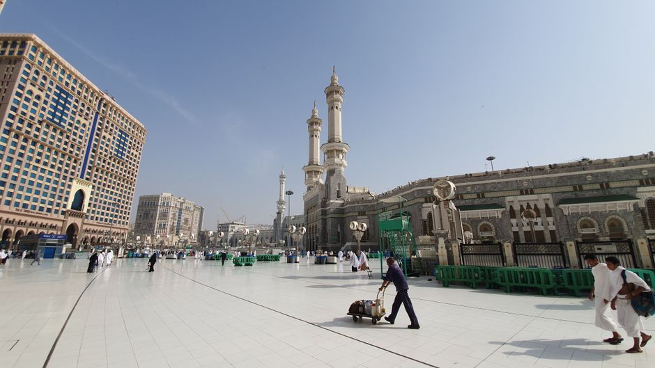 Pilgrims walking near Masjid al-Haram in Makkah with umbrellas