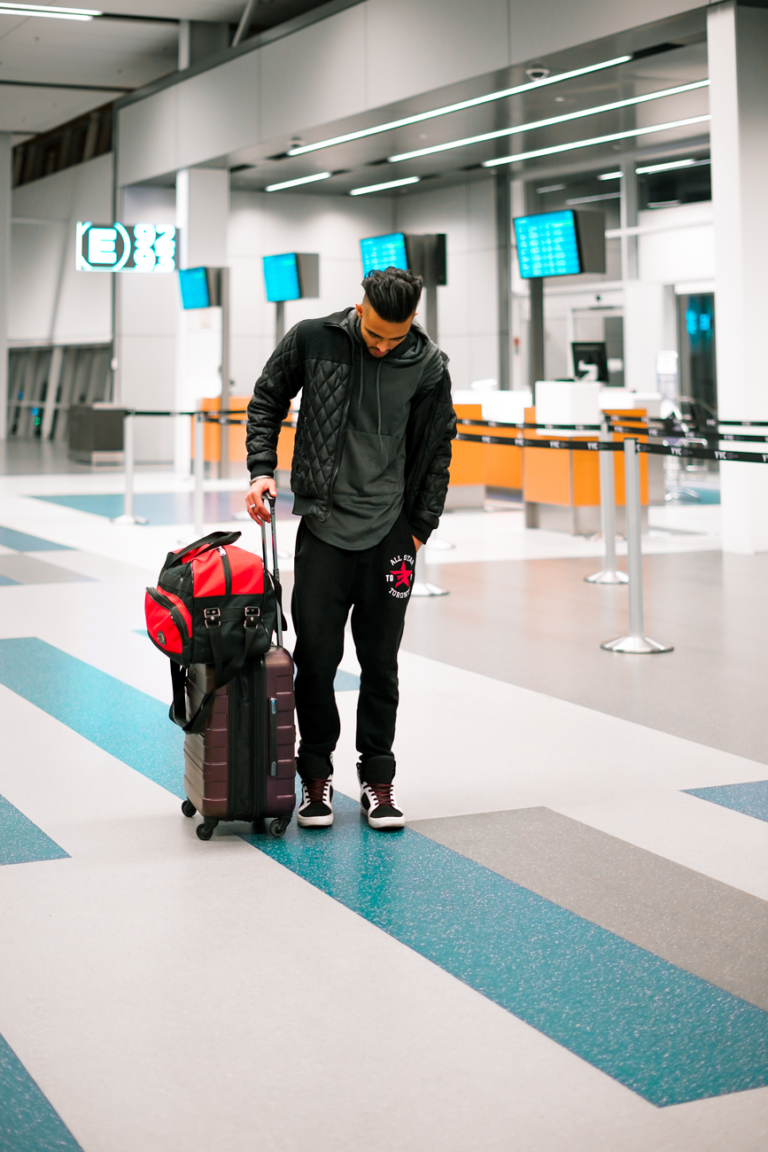 Traveller with wheeled luggage in an airport terminal