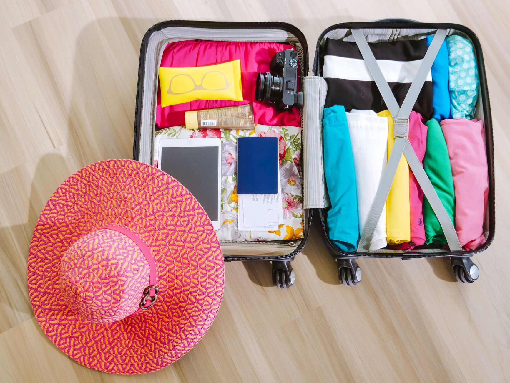 Open suitcase packed with clothes and travel essentials