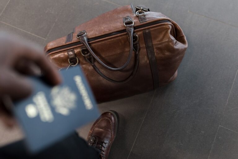 Brown leather bag with passport in an airport setting